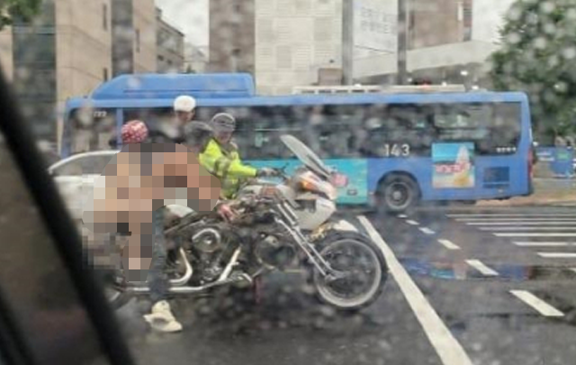 지난달 31일 비 오는 강남 도로에서 상의를 탈의한 남성과 비키니 수영복 차림의 여성이 오토바이를 타고 질주하는 모습이 포착됐다. 온라인 커뮤니티 캡처