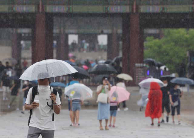 태풍 송다의 영향으로 전국적으로 비가 내린 지난달 31일 오후 서울 경복궁을 찾은 시민과 외국인들이 우산을 쓰고 있다. 연합뉴스