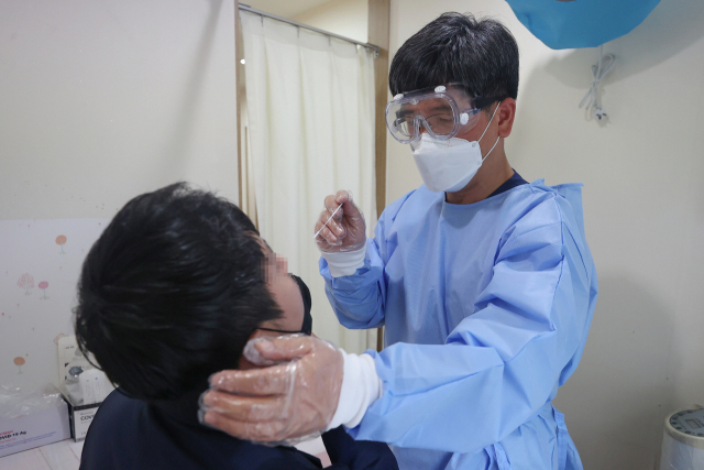 2일 오후 서울 시내의 한 병원에서 의사가 신속항원검사를 하고 있다. 연합뉴스