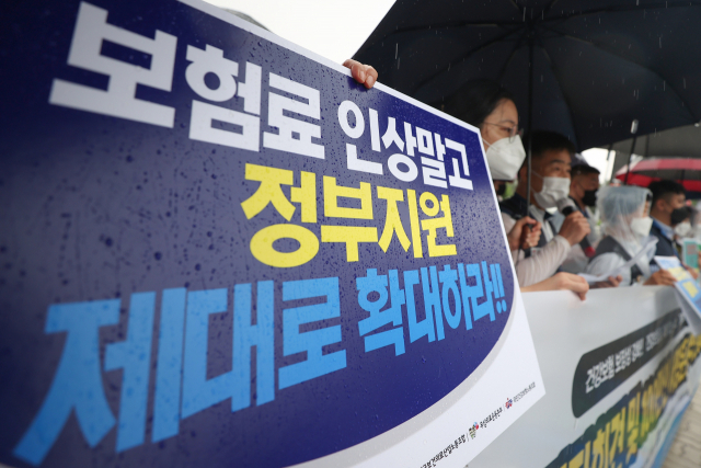 시민단체 회원들이 7월 서울 여의도에서 건강보험에 대한 정부 지원을 늘리라는 내용의 시위를 펼치고 있다. 연합뉴스