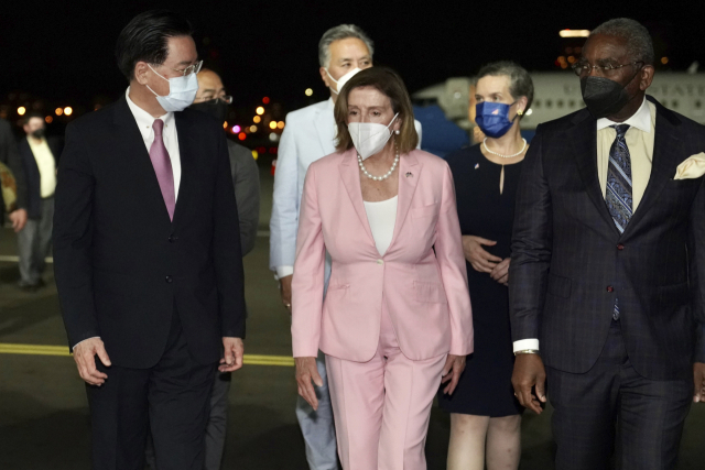 대만 타이페이 쑹산 공항에 2일(현지시간) 밤 도착한 낸시 펠로시 미국 하원의장(가운데)이 우자오셰 대만 외교부장(왼쪽)의 영접을 받으며 걸어가고 있다./AP연합뉴스