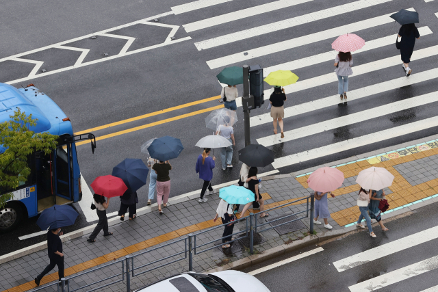 서울 송파구 잠실역 인근 교차로에서 우산을 쓴 시민들이 횡단보도를 건너고 있다. 연합뉴스
