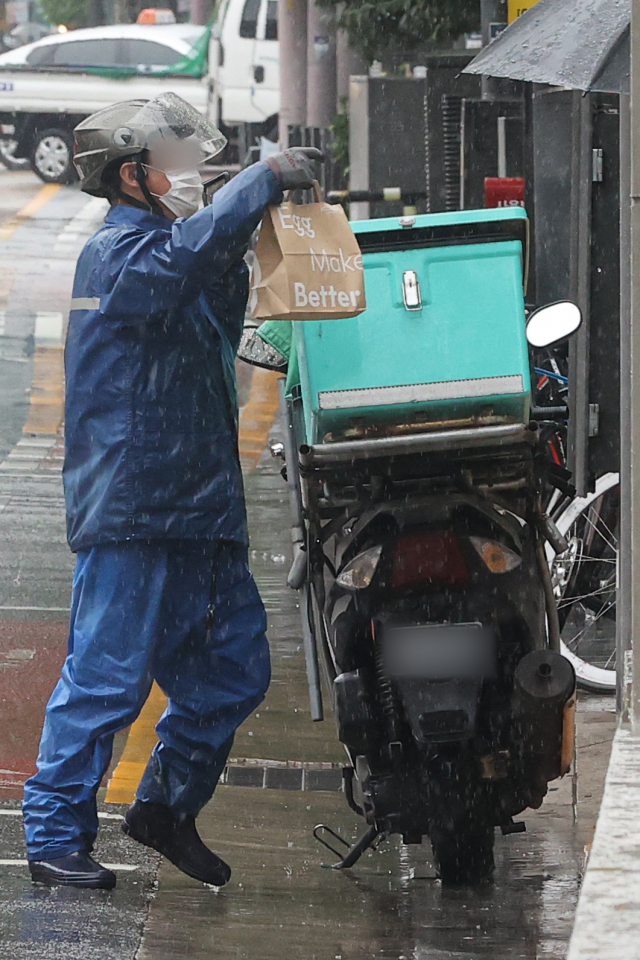 점심시간 한 배달원이 서울 종로구 종각 젊음의거리 인근에서 음식을 배달하고 있다.연합뉴스
