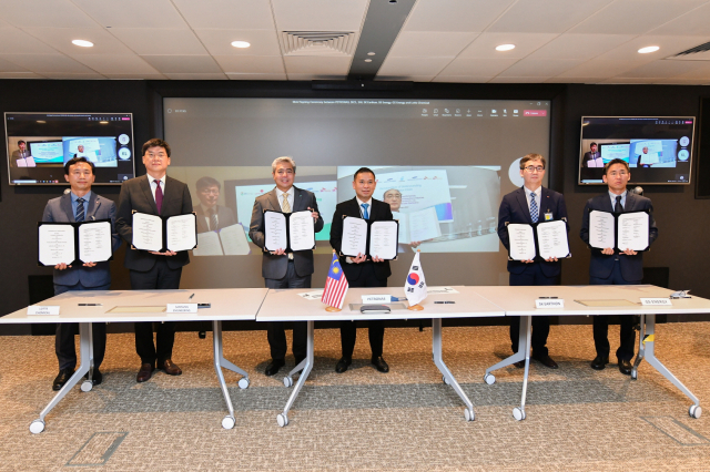 2일 말레이시아 쿠알라룸푸르 페트로나스 트윈타워에서 ‘셰퍼드 CCS 프로젝트’에 참여하는 한국과 말레이시아 기업 관계자들이 업무협약서를 들어보이고 있다. 사진 제공=SK이노베이션