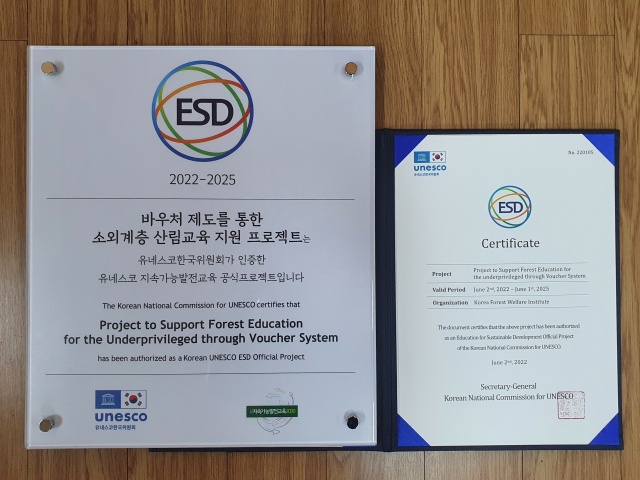 한국산림복지진흥원이 유네스코로부터 받은 ESD 공식 프로젝트 현판과 인증서. 사진제공=한국산림복지진흥원