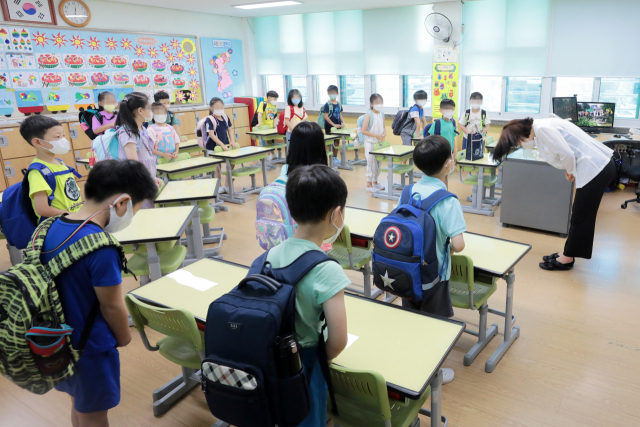 지난달 15일 오후 서울 중구 청구초등학교에서 방학을 맞은 학생들이 선생님과 인사를 나누고 있다. 연합뉴스