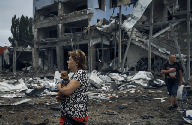 한 우크라이나 주민이 3일(현지시간) 러시아군의 폭격으로 폐허가 된 우크라이나 미콜라이우의 한 건물 앞에서 강아지를 안고 서성이고 있다. 미콜라이우는 러시아 점령지 남부 헤르손과 가장 인접한 지역으로 최근 러시아군의 집중 공습 대상이 되고 있다. AP연합뉴스