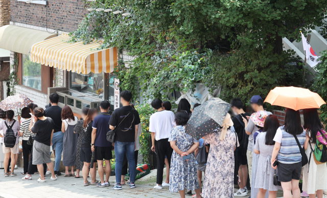 지난 4일 오전 드라마 '이상한 변호사 우영우' 촬영지인 경기도 수원시 팔달구 행궁동의 한 식당에 시민들이 입장을 기다리며 줄을 서 있다. 연합뉴스