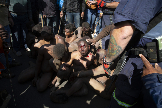 남아프리카공화국 모델을 집단 성폭행한 혐의를 받는 불법체류 광부들을 주민들이 직접 응징한 모습. AP연합뉴스
