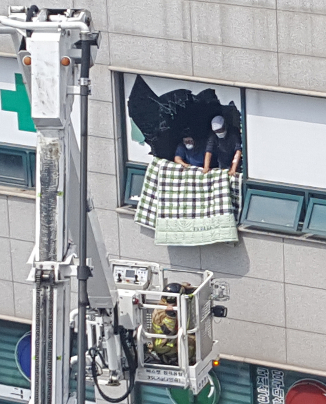 5일 경기도 이천시 관고동 병원 건물에서 화재가 발생해 소방대원이 구조를 시도하고 있다. 연합뉴스