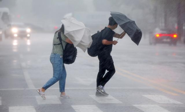 장마가 다시 시작된 8일 오후 서울 영등포구의 한 횡단보도에서 우산을 쓴 시민들이 길을 건너고 있다. 연합뉴스