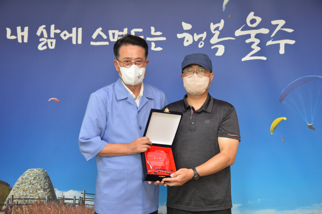 개에 물린 아동을 구한 김건휘(오른쪽)씨가 8일 울주군청에서 이순걸 군수에게 용감한 의인 감사패를 받고 있다. 사진제공=울산시 울주군