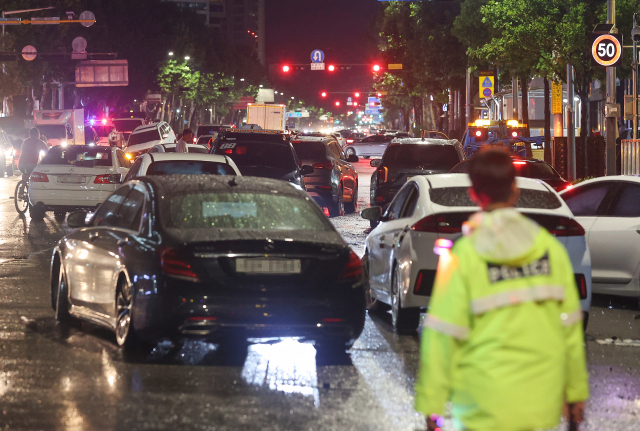 폭우가 내린 9일 오전 서울 강남구 대치역 인근 도로에 침수됐던 차들이 차량 통행을 방해하고 있다. 연합뉴스