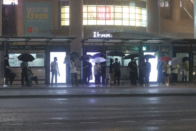 폭우가 내린 8일 오후 시민들이 서울 용산구 용산역 인근 정류장에서 버스를 기다리고 있다. 연합뉴스