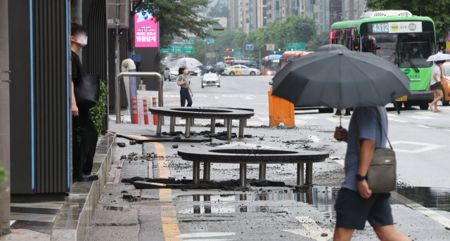 9일 오전 서울 강남역 일부 도로가 전날 내린 폭우에 파손돼 있다. 연합뉴스