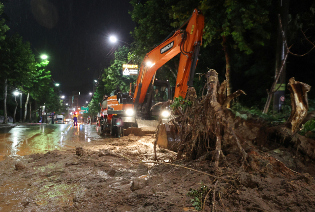 폭우가 내린 9일 오전 서울 서초구의 한 도로에 산사태가 발생해 일부 차선 통제와 복구 작업이 이뤄지고 있다. 연합뉴스