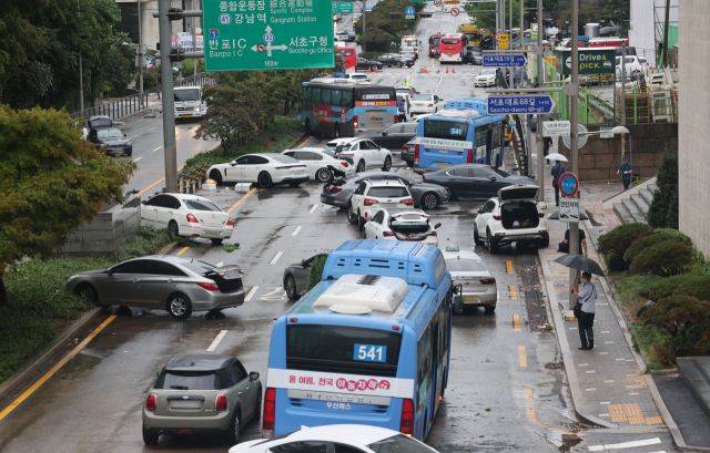 9일 오전 서울 서초구 진흥아파트 앞 서초대로 일대에서 전날 내린 폭우에 침수됐던 차량이 모습을 드러내고 있다. /연합뉴스