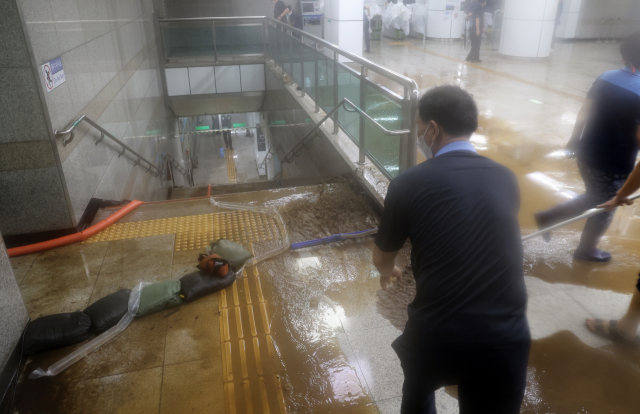 지난 8일 밤 폭우로 침수된 지하철 이수역에서 관계자들이 청소하고 있다./연합뉴스