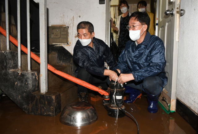 이민근(오른쪽) 안산시장 9일 반월동장과 함께 침수 주택을 찾아 배수펌프를 작동하고 있다. /사진제공=안산시