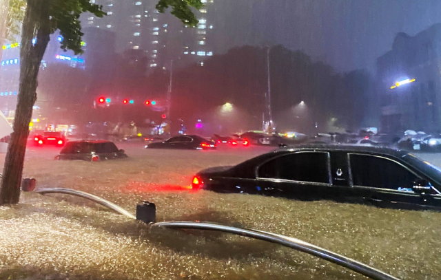 서울에 집중호우가 내린 8일 밤 서울 대치역 인근 도로가 침수되고 차량이 물에 잠겨 있다. 연합뉴스