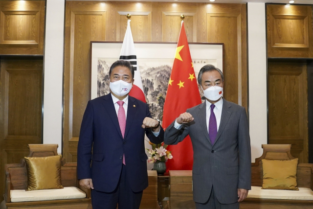 박진 외교부 장관이 9일 왕이 중국 외교부장과 중국 칭다오에서 회담을 하기 전 팔꿈치를 부딪치고 있다. 외교부