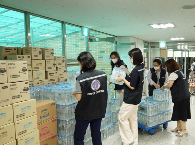 이디야커피 직원들이 기록적 폭우로 피해를 입은 서울 강남구 구룡마을 이재민들에게 전달할 물품을 점검하고 있다. 사진 제공=이디야커피
