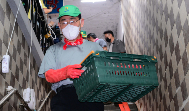 주호영 국민의힘 비상대책위원장이 11일 오전 서울 동작구 사당동 한 빌딩 지하에서 수해 복구 자원봉사를 하고 있다.