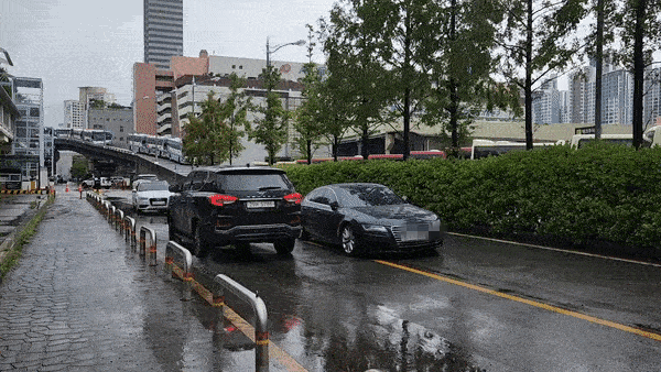 80년 만에 기록적인 폭우가 쏟아진 가운데 9일 서울 서초구 고속버스터미널 파미에스테이션 주차장으로 가는 길목에 침수 차량 여러 대가 덩그러니 방치되어 있다. 그 바람에 이 도로를 지나는 차들은 S자로 꺾어 가까스로 길을 지나가야 했다. 김남명 기자