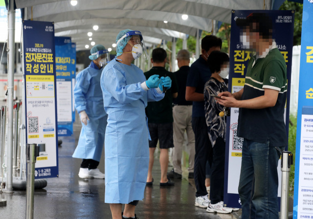 임시선별검사소에서 의료진이 코로나19 검사를 받으려는 시민들을 안내하고 있다./연합뉴스