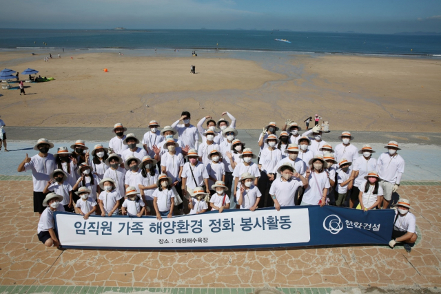 12일 한화건설 임직원 가족들이 대천해수욕장 해양환경 정화 봉사활동에 참여하고 기념사진을 촬영하고 있다. /사진제공=한화건설