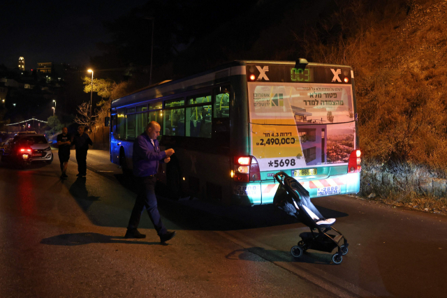 이스라엘 경찰들이 14일(현지시간) 예루살렘 구시가지에서 총기난사가 발생한 버스 주변을 조사하고 있다. 예루살렘=AFP연합뉴스