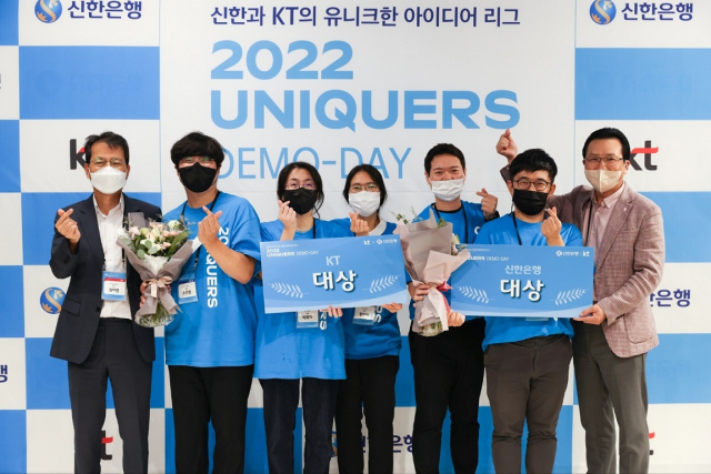 지난 12일 서울시 강남구 소재 코엑스에서 개최한 ‘2022 UNIQUERS DEMO-DAY’ 에서 대상을 수상한 신한은행의 D-ART팀과 KT의 안녕팀, 신한은행 디지털개인부문 전필환 부행장(오른쪽 첫번째), KT 융합기술원장 김이한 전무(왼쪽 첫번째)가 기념 촬영을 하고 있다. 사진 제공=신한은행