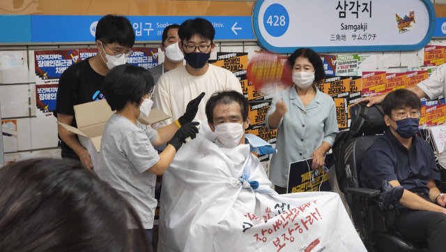 전국장애인차별철폐연대(전장연) 관계자들이 지난 3일 서울 용산구 4호선 삼각지역 승강장에서 장애인 권리 예산 보장을 촉구하며 삭발 시위를 벌이고 있다. 연합뉴스