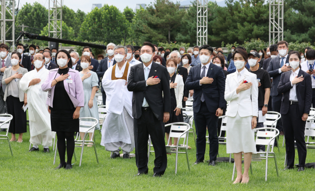 윤석열 대통령과 김건희 여사가 지난 15일 서울 용산 대통령실 청사 잔디마당에서 열린 제77주년 광복절 경축식에서 국기에 경례를 하고 있다. 윤 대통령 오른쪽 옆의 분홍색 재킷을 입은 여성은 독립유공자 장성순씨의 증손녀 변해원씨. 연합뉴스