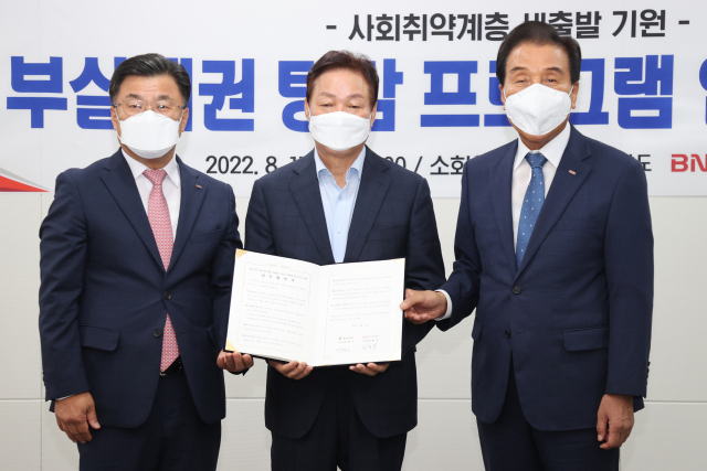 박완수(가운데) 경상남도지사와 김지완(오른쪽) BNK금융지주 회장, 최홍영 BNK경남은행장이 17일 경남 지역 사회취약계층의 새출발을 위한 ‘부실채권 탕감 프로그램 업무협약’을 체결하고 촬영을 하고 있다. /사진제공=경남도