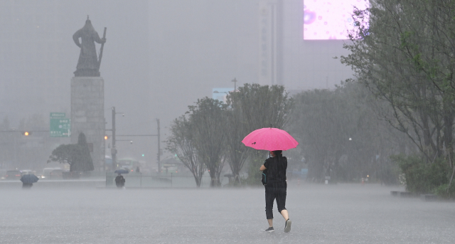 시민들이 19일 서울 광화문광장에서 갑자기 내린 폭우를 피해 발길을 재촉하고 있다. 오승현 기자