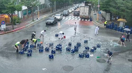 지난 6월 29일 강원도 춘천에서 맥주 박스를 쏟은 차주를 도와 도로를 정비하는 시민들의 모습. 유튜브 캡처