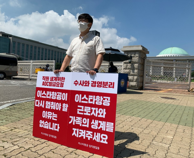 이스타항공 근로자가 23일 서울 여의도 국회의사당 앞에서 AOC 발급 절차 진행을 촉구하는 1인 피켓 시위를 하고 있다. 사진 제공=이스타항공
