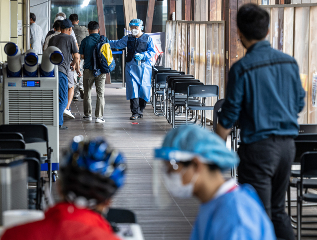 24일 오전 서울 송파구 송파구보건소 선별진료소에서 관계자가 검사를 받으러 온 시민들에게 안내하고 있다. 연합뉴스