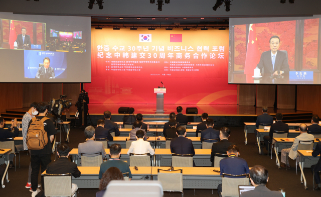 리커창(오른쪽) 중국 총리가 24일 서울 중구 대한상의 국제회의장에서 열린 한중 수교 30주년 기념 비즈니스 포럼에서 영상 축사를 하고 있다. 리 총리는 
