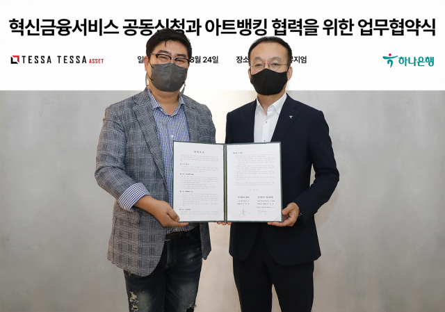 24일 서울 성수동 테사 본사에서 열린 업무협약식에 참석한 김기석(오른쪽) 하나은행 자산관리그룹 부행장과 김형준 테사 대표가 업무협약서를 들고 기념촬영을 하고 있다. 사진 제공=하나은행