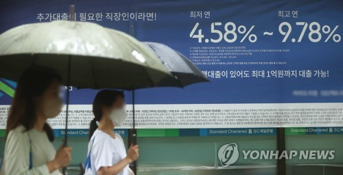 지난달 서울 시내 한 시중은행 외벽에 붙은 대출 금리 관련 안내문 앞을 시민들이 지나고 있다. 연합뉴스