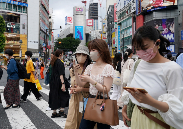 지난달 21일 일본 도쿄 시내에서 행인들이 횡당보도를 건너고 있다. 일본의 코로나 19 신규 확진자는 당시 18만명을 넘어서며 이틀 연속 사상 최고치를 기록했다. 도쿄 EPA=연합뉴스