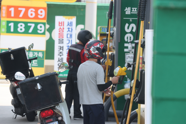 지난 21일 오토바이 운전자가 서울 시내 주유소에서 주유를 하고 있다. 연합뉴스