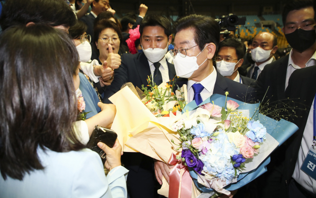 더불어민주당 이재명 신임 당 대표가 28일 서울 송파구 올림픽 체조경기장에서 열린 제5차 정기전국대의원대회에서 당대표로 선출 된 뒤 지지자들로부터 축하를 받고 있다/연합뉴스