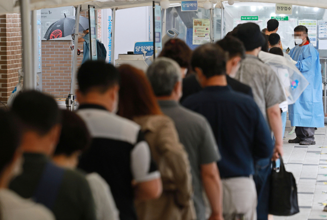 코로나19 신규 확진자가 4만 3142명을 기록한 29일 오전 서울 마포구보건소 코로나19 선별진료소를 찾은 시민들이 검사를 위해 줄을 서 있다. 연합뉴스