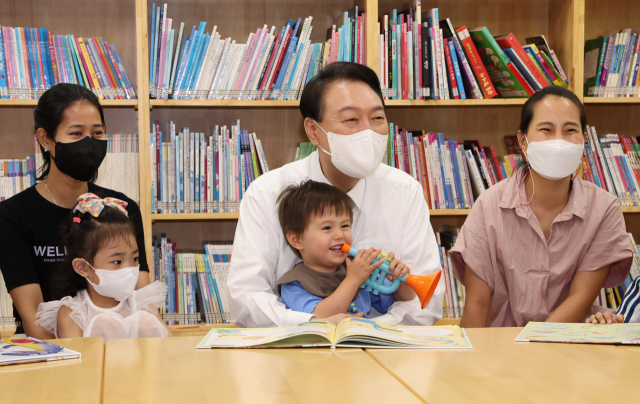 윤석열 대통령이 30일 오전 서울 구로구 가족센터를 방문, 공동육아나눔터에서 공동 육아에 대한 설명을 들은 후 아이들과 함께 그림동화책을 보고 있다./연합뉴스