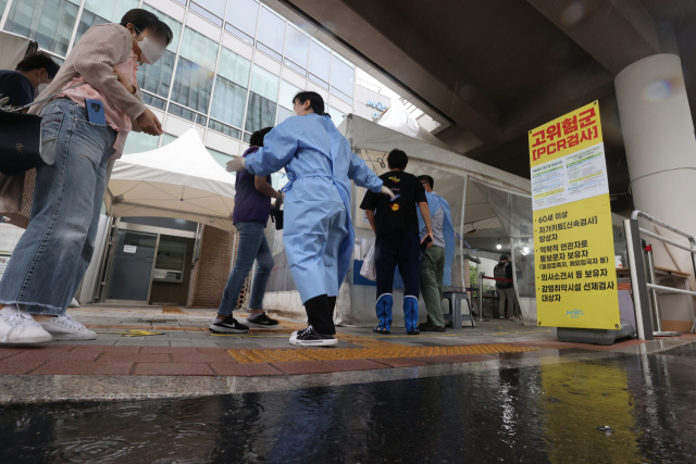 비가 내린 30일 오전 시민들이 서울 마포구 보건소 선별진료소에서 코로나19 검사를 위해 차례를 기다리고 있다. 연합뉴스