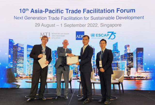 30일 싱가포르에서 열린 ‘아시아·태평양 무역원활화 포럼’에서 차영환(오른쪽 두번째) KTNET의 대표가 파울 한센(왼쪽 두번째)UNCTAD장으로부터 ‘무역원활화 혁신상’을 받고 악수하고 있다. 사진제공=KNET