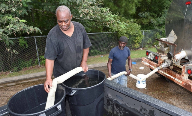 미국 미시시피주 잭슨시 주민들이 컨테이너에 물을 담고 있다. EPA 연합뉴스